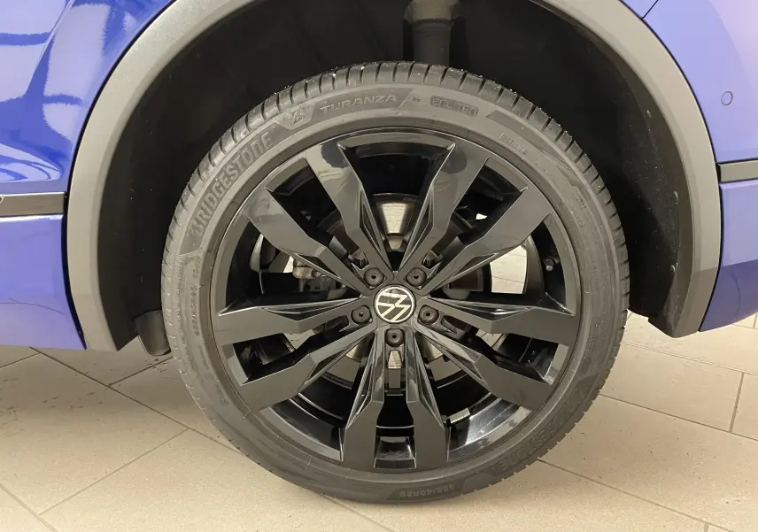 Gros plan sur la jante noire 20'' Suzuka du Volkswagen Tiguan Bleu Lapiz, côté arrière droit du véhicule.