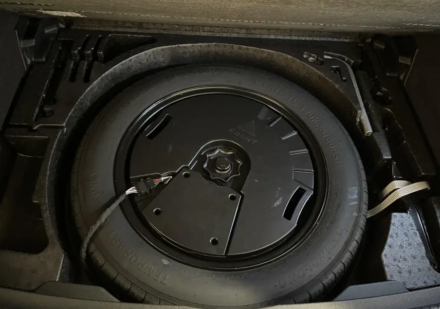 Roue de secours compacte dans le coffre du Volkswagen Tiguan 2022, détail du plancher de chargement variable.