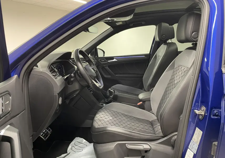 Vue intérieure côté conducteur du Volkswagen Tiguan Bleu Lapiz 2022 avec sièges R-Line en cuir et alcantara.