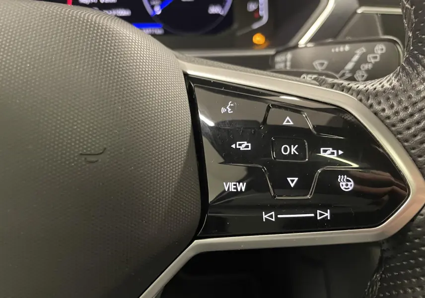 Gros plan sur les commandes noires du volant multifonction du Volkswagen Tiguan 2.0 TDI 2022.