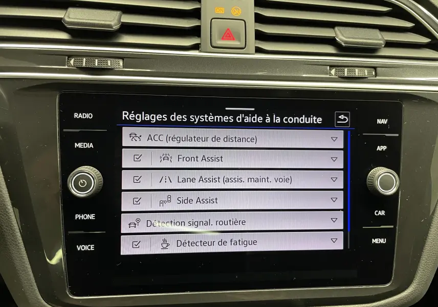 Écran tactile intérieur du Volkswagen Tiguan 2022 affichant les réglages des aides à la conduite.