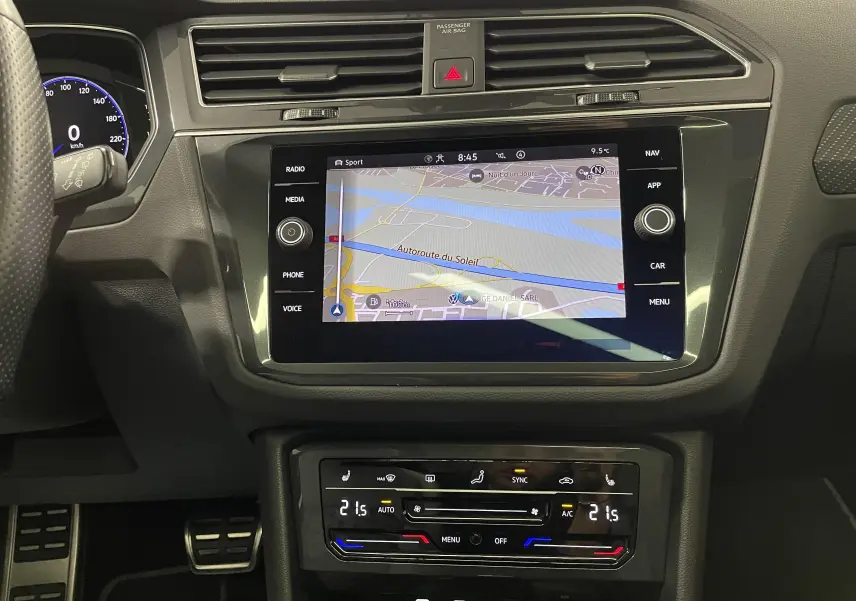 Vue rapprochée de l’écran tactile central et de la console de climatisation du Volkswagen Tiguan 2022, intérieur noir.