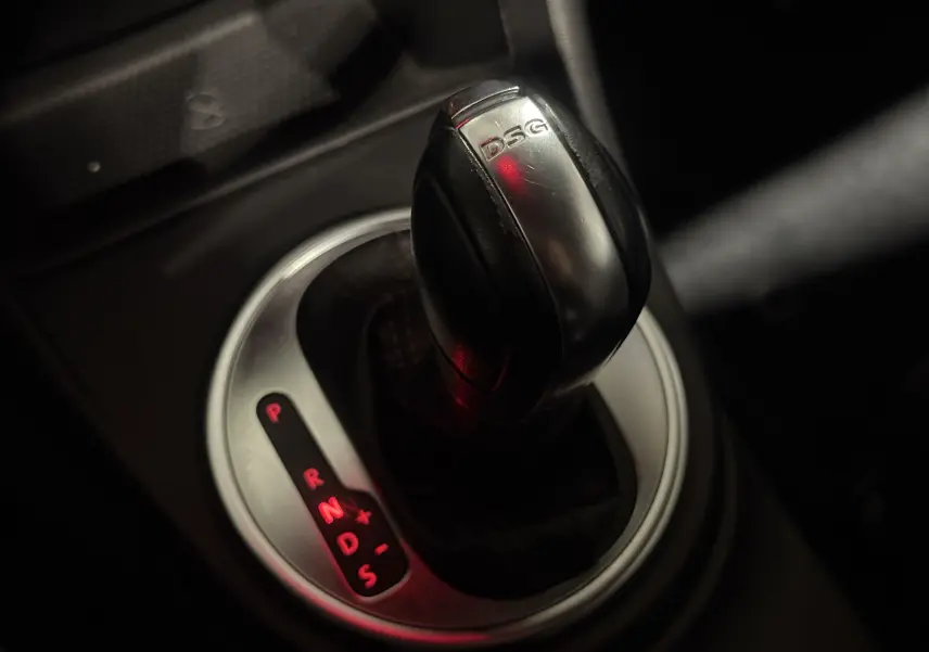 Gros plan sur le levier de vitesses DSG noir et argenté de la Volkswagen Coccinelle 2013, éclairage rouge des modes.