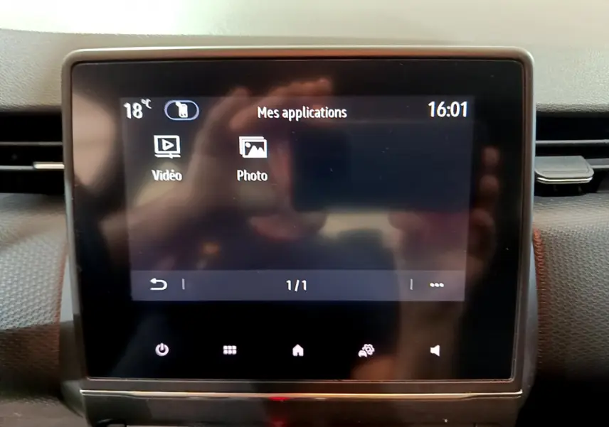 Écran tactile central affichant les applications vidéo et photo dans l’habitacle d’une Renault Clio Business blanche.