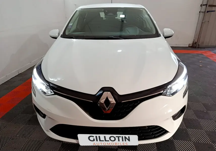 Vue avant d'une Renault Clio Business TCe 90 blanche avec phares LED allumés dans un garage.