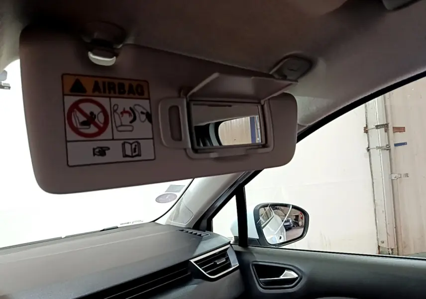 Intérieur de la Renault Clio Business TCe 90 2021, vue côté passager avec pare-soleil ouvert et miroir visible.