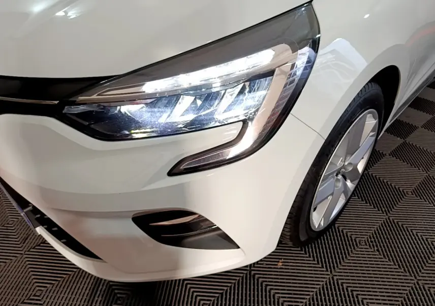 Gros plan sur le phare avant droit et la roue d’une Renault Clio Business TCe 90 blanche de 2021.