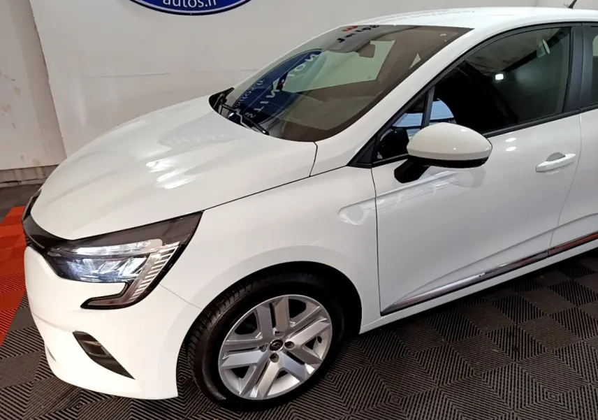 Vue 3/4 avant droit d'une Renault Clio Business TCe 90 blanche avec phares LED et jantes alliage argentées.