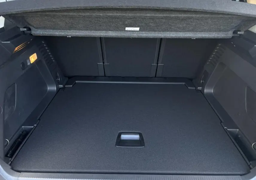 Coffre ouvert vu de l'arrière du Citroën C5 Aircross gris Platinium, montrant le plancher modulable et l'éclairage intérieur.
