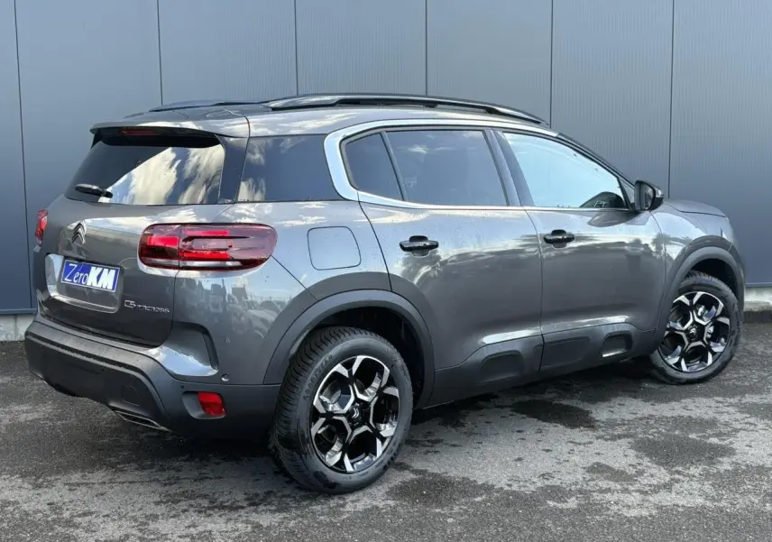 Vue 3/4 arrière droite du Citroën C5 Aircross gris Platinium avec jantes bi-ton et toit ouvrant panoramique.