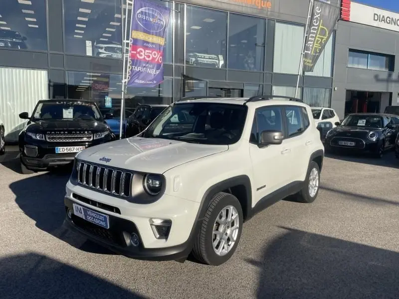 Jeep Renegade blanc vue 3/4 avant droit, avec calandre distinctive à sept fentes et jantes argentées, stationné en extérieur.