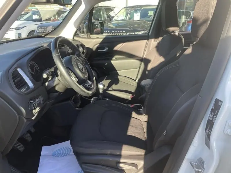 Intérieur du Jeep Renegade blanc 2019, vue côté conducteur montrant sièges noirs et levier de vitesse manuel.