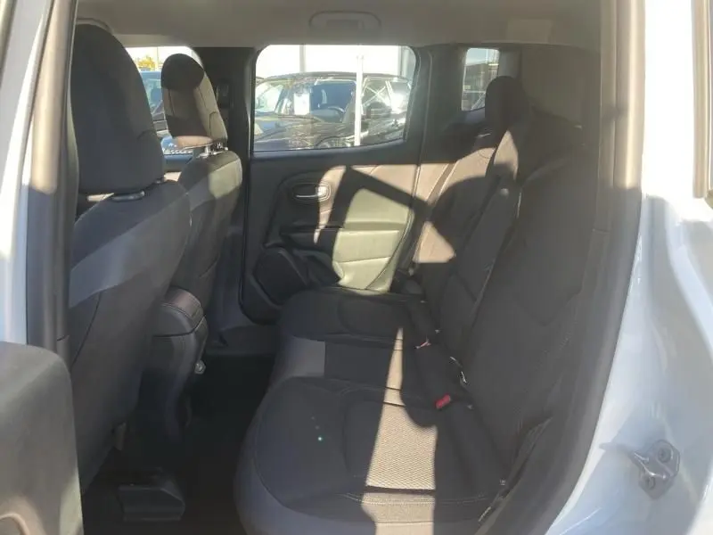Vue intérieure arrière droite du Jeep Renegade blanc 2019, montrant les sièges arrière en tissu noir et la porte ouverte.