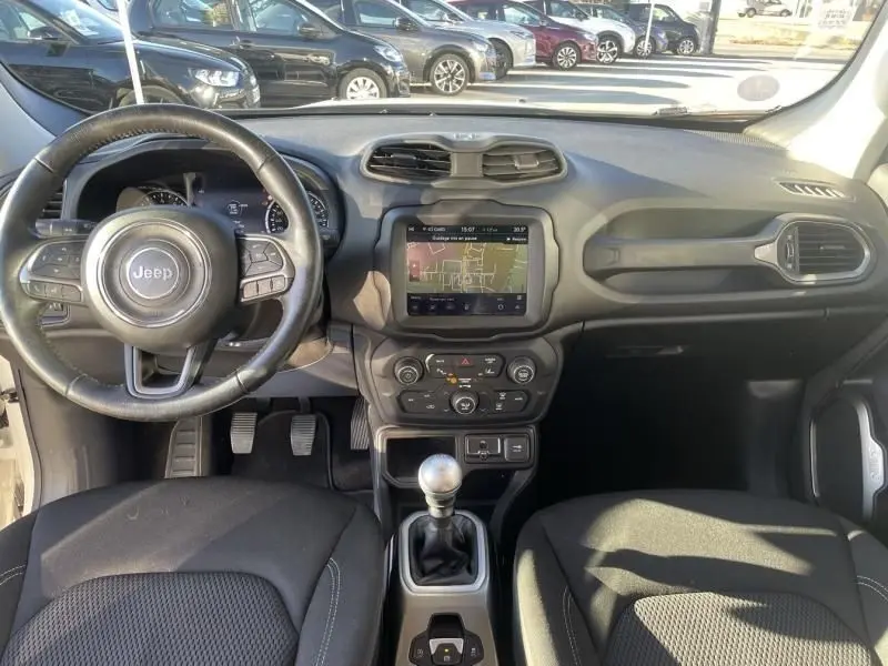Vue intérieure avant du Jeep Renegade 2019 avec tableau de bord noir, volant multifonction et boîte manuelle.