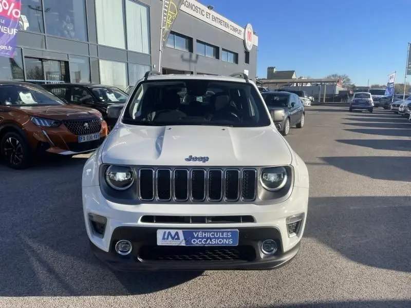 Vue de face d’un Jeep Renegade blanc 2019 avec calandre à sept barres et phares ronds, sur un parking de concession.