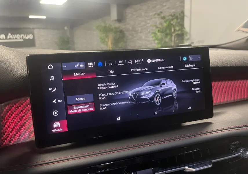 Écran tactile intérieur affichant les modes de conduite de l'Alfa Romeo Tonale 2024 avec habillage rouge et surpiqûres.