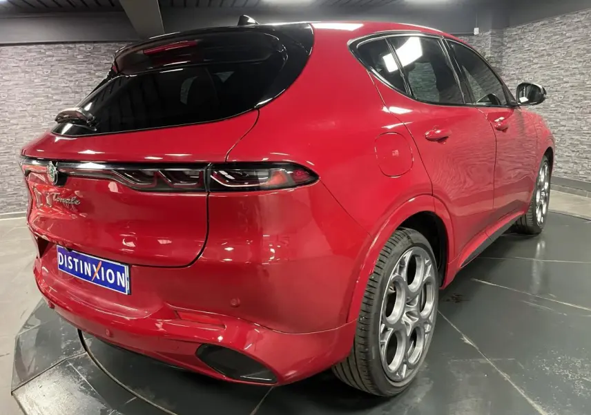 Vue 3/4 arrière droite de l'Alfa Romeo Tonale rouge avec toit noir et jantes alliage 20 pouces Competizione.