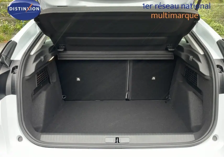Coffre ouvert vu de l'arrière d'une Citroën C4 blanc métal, montrant un espace de chargement propre et spacieux.