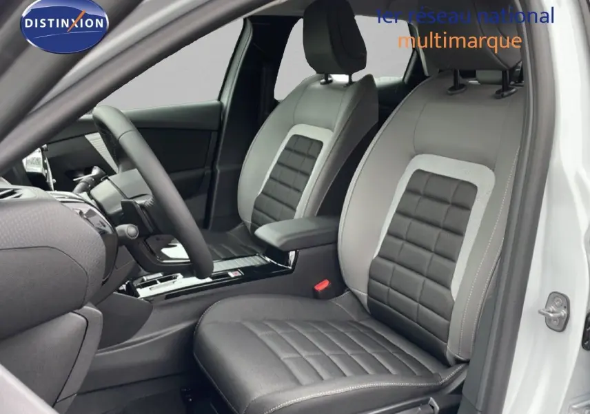 Vue intérieure côté conducteur d'une Citroën C4 blanc métal, sièges en cuir et tissu noir avec surpiqûres grises.