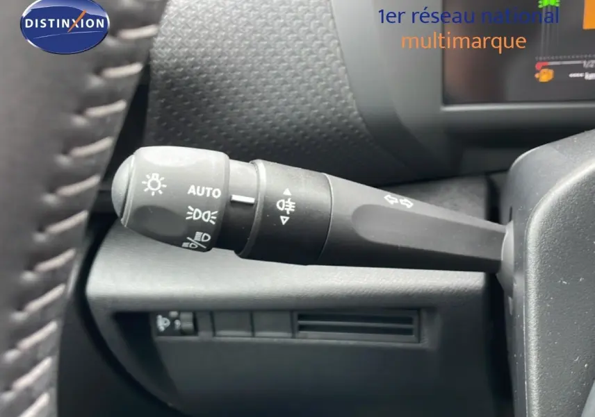 Gros plan sur la commande des phares à gauche du volant d’une Citroën C4 blanc métal, version PureTech 130ch.