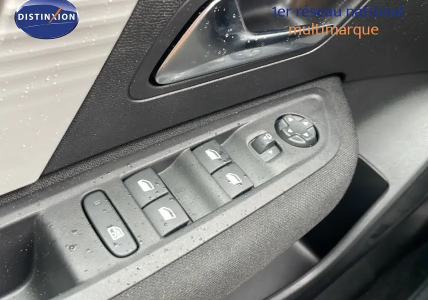 Détail de la commande des vitres et rétroviseurs côté conducteur d'une Citroën C4 blanc métal, intérieur noir.