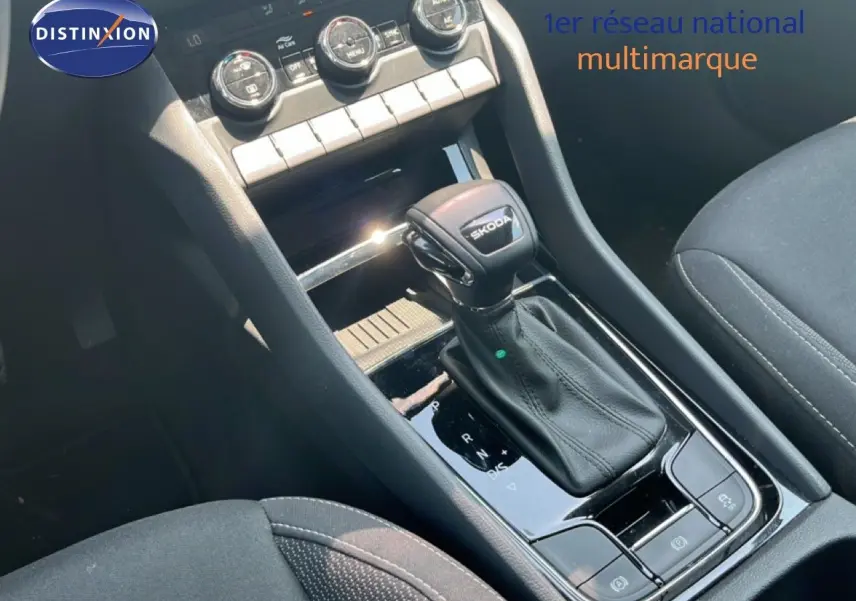 Gros plan sur la console centrale d’un Skoda Karoq 2025, levier de vitesse DSG noir avec logo Skoda visible.