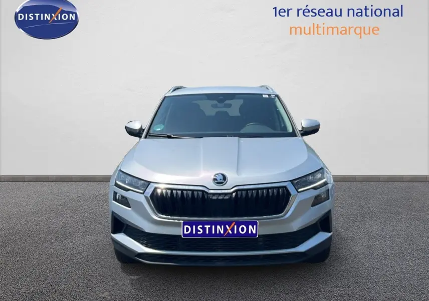 Vue frontale d'un Skoda Karoq 2025 en argent Reflex Silver Metal, avec calandre noire et phares LED allumés.