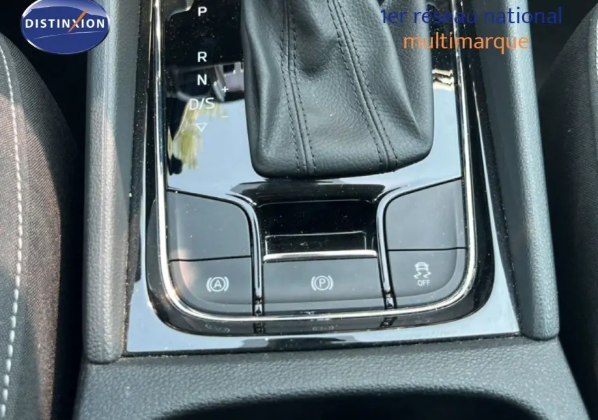 Gros plan sur la console centrale noire brillante avec levier de vitesse cuir et boutons de contrôle du SKODA KAROQ 2025.