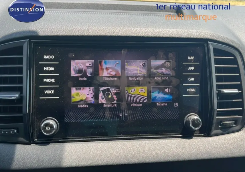 Écran tactile central du Skoda Karoq 2025 affichant les menus radio, navigation et téléphone, entouré de commandes.