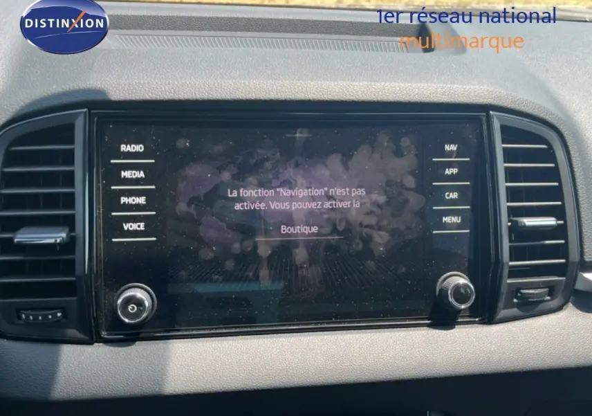 Écran tactile central du tableau de bord du Skoda Karoq 2025, avec commandes radio et navigation visibles.