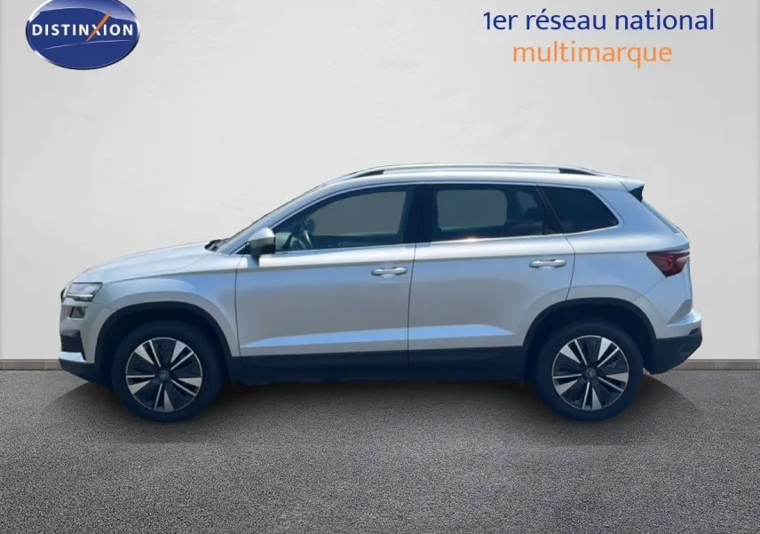 Vue latérale droite d'un Skoda Karoq 2025 en Reflex Silver Metal, soulignant ses jantes bi-ton et ses lignes modernes.