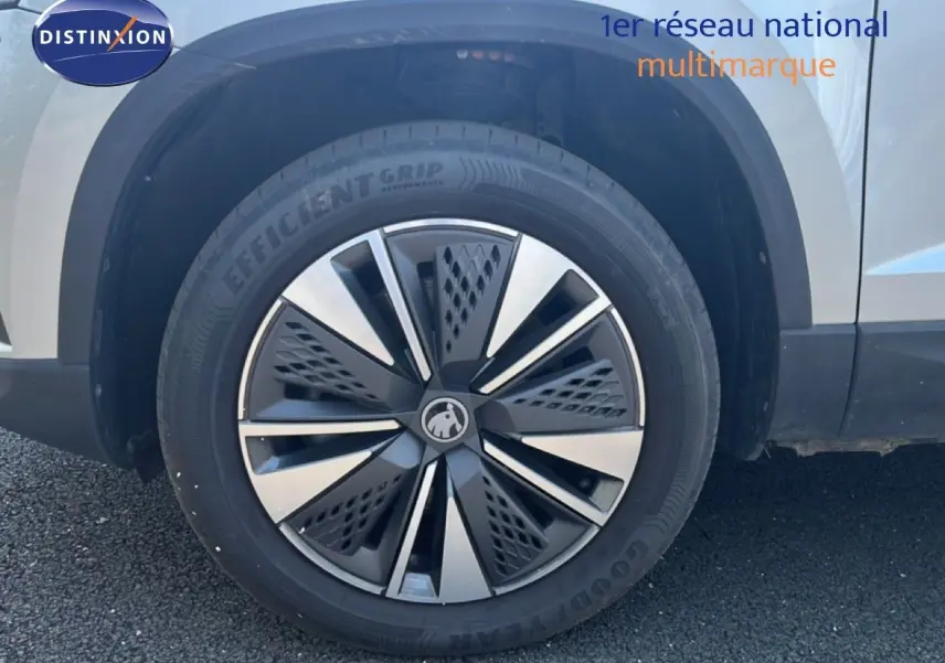 Gros plan sur la roue avant droite d’un Skoda Karoq Reflex Silver Metal, mettant en valeur la jante design bicolore.