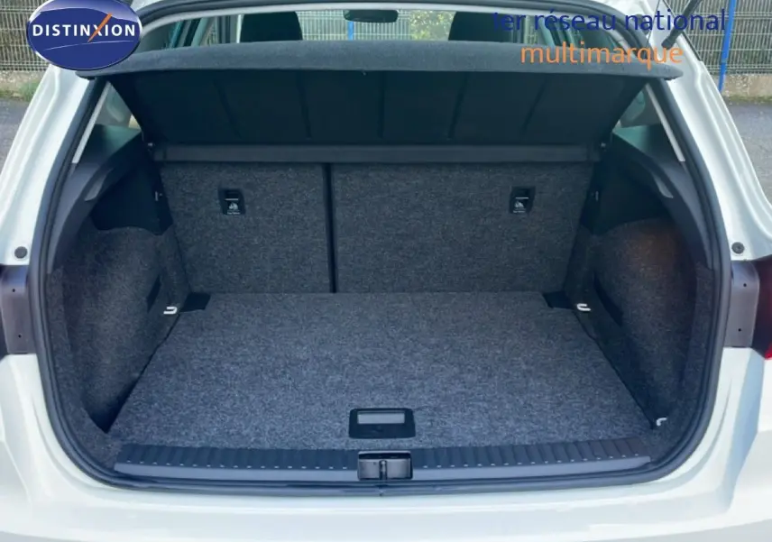 Coffre ouvert vu de l'arrière d'un SEAT Arona blanc avec toit gris, montrant l'espace de chargement vide et tapissé.