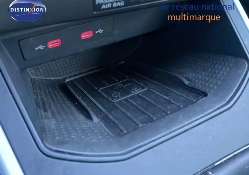 Gros plan sur la console centrale du SEAT Arona 2025, montrant la zone de recharge sans fil et deux ports USB rouges.