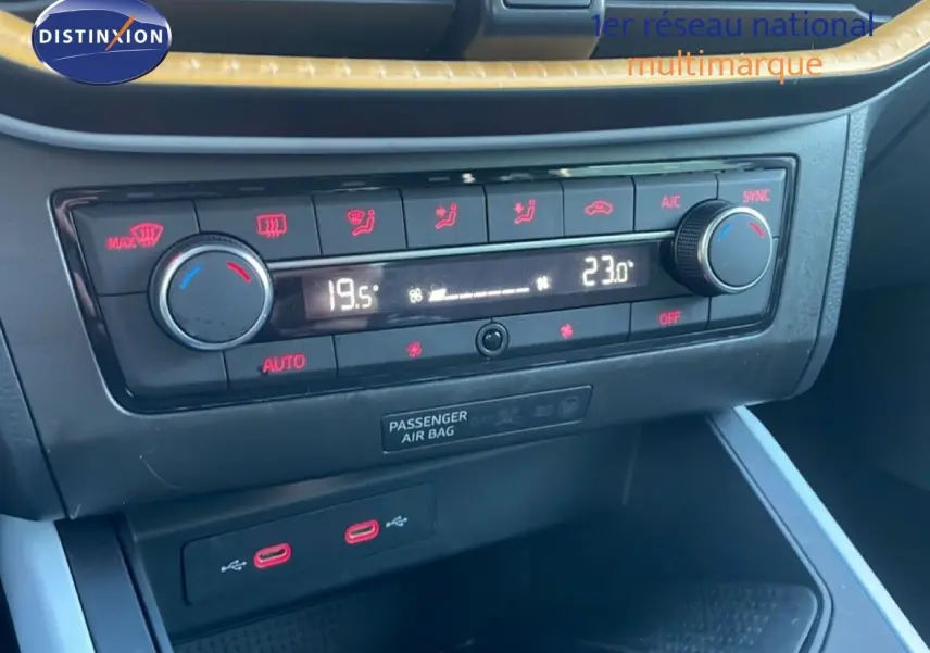 Gros plan sur la console centrale du SEAT Arona 2025, montrant la climatisation bi-zone et deux ports USB-C rouges.