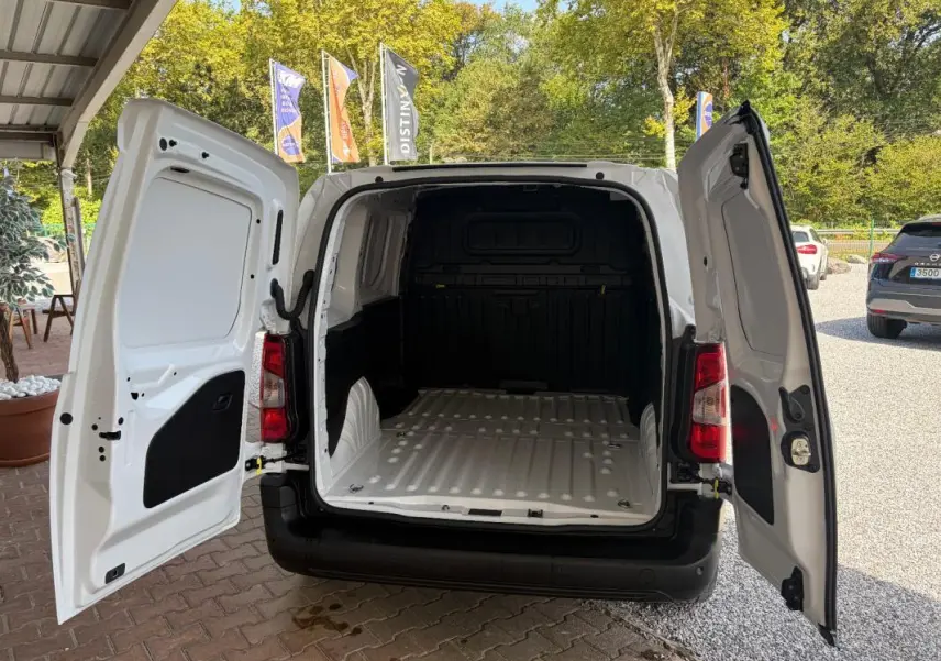 Vue arrière du Peugeot Partner blanc 2026 avec portes arrière ouvertes montrant l’espace de chargement vide.