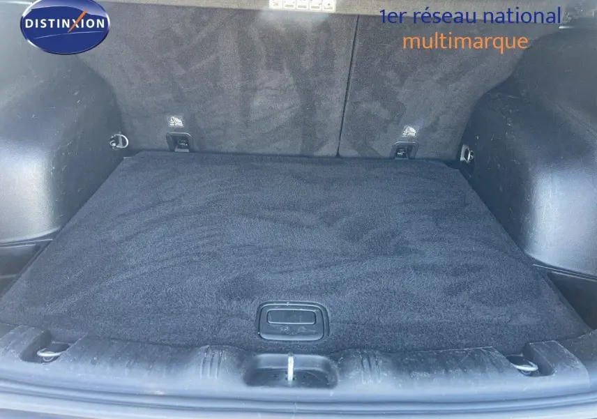 Coffre ouvert du Jeep Compass gris foncé, vue de l'arrière montrant l'espace de chargement propre et tapis noir.