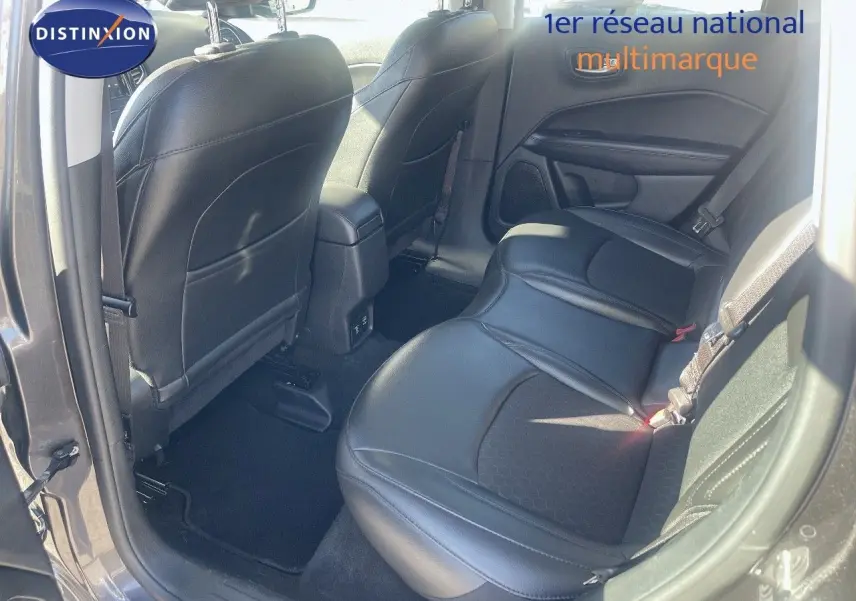 Vue intérieure arrière côté droit du Jeep Compass gris foncé, montrant les sièges en cuir noir et la porte ouverte.