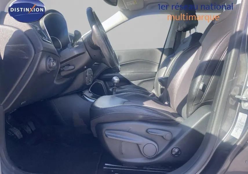 Vue intérieure côté conducteur du Jeep Compass gris foncé 2019, mettant en valeur les sièges en cuir et la boîte manuelle.