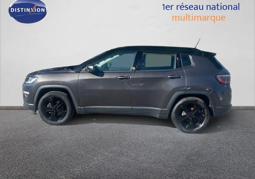 Vue de profil côté gauche d'un Jeep Compass gris foncé Brooklyn Edition 2019 avec jantes noires et toit noir.