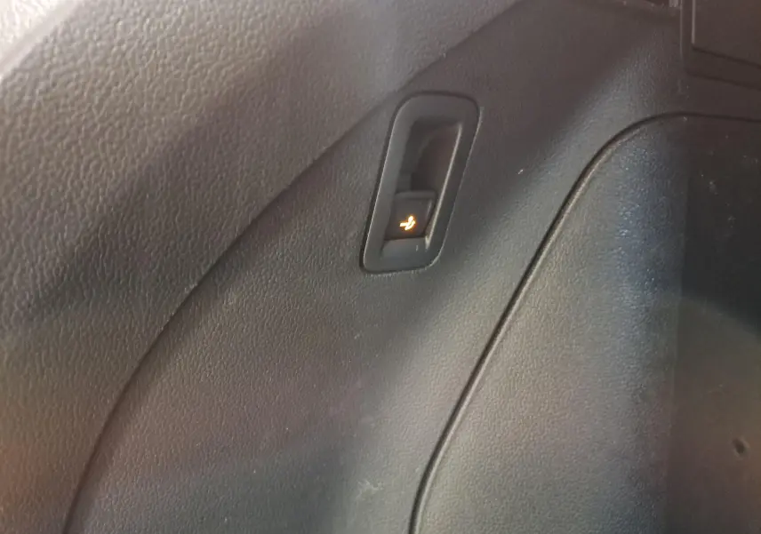 Gros plan sur le bouton de rabattement électrique des sièges dans l'habitacle noir du Volkswagen Tiguan 2023.