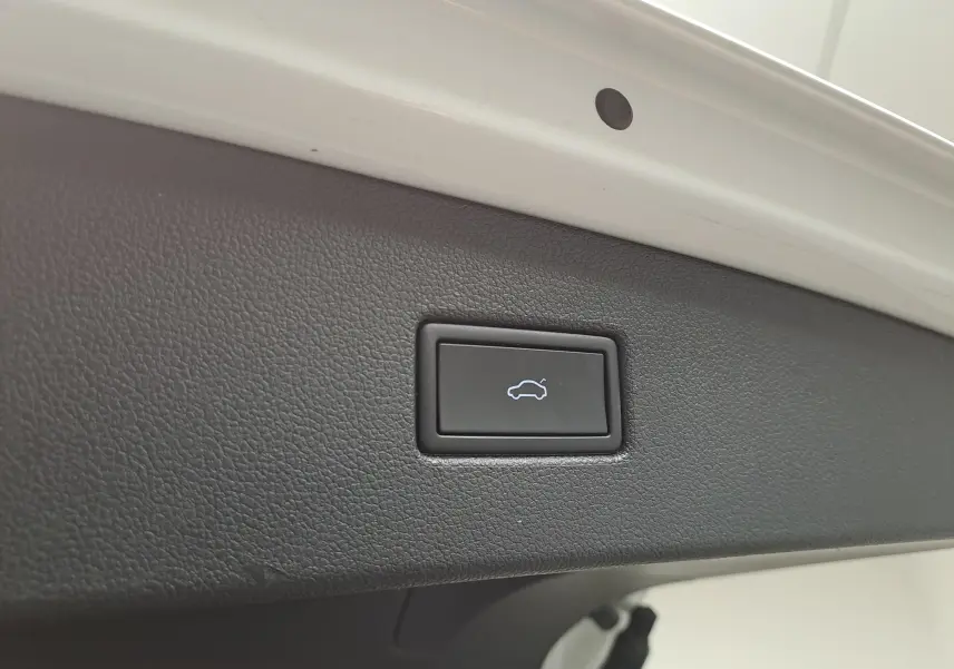 Bouton d'ouverture électrique du hayon sur la garniture intérieure blanche nacrée du Volkswagen Tiguan 1.4 eHybrid 2023.