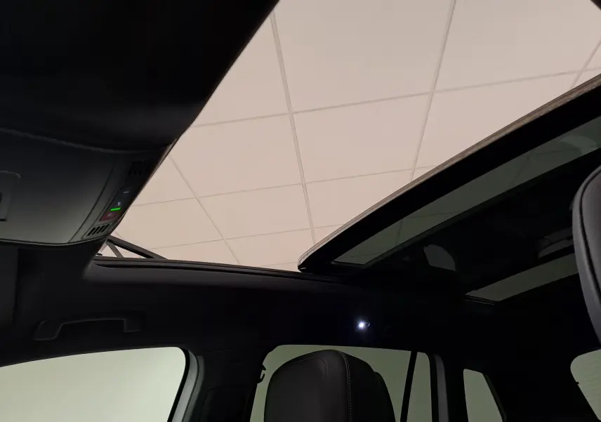 Toit panoramique ouvert et intérieur noir du Volkswagen Tiguan 1.4 eHybrid 2023, vue côté gauche.