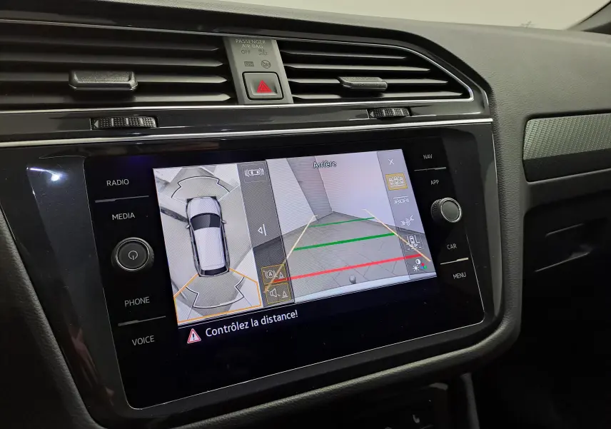 Écran central du Volkswagen Tiguan 2023 montrant la caméra de recul et la vue 360° intérieure, tableau de bord noir.