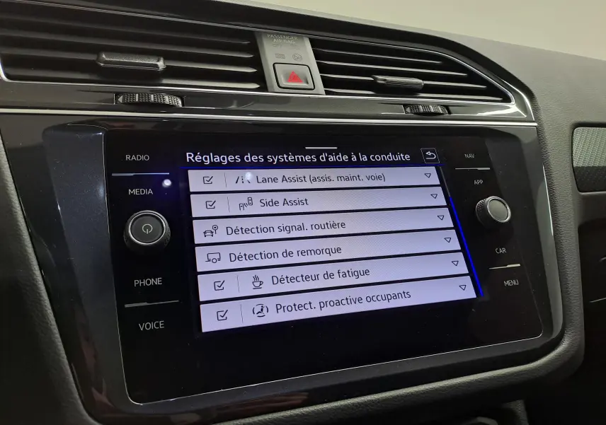 Écran tactile du tableau de bord du Volkswagen Tiguan 2023 affichant les réglages des aides à la conduite.