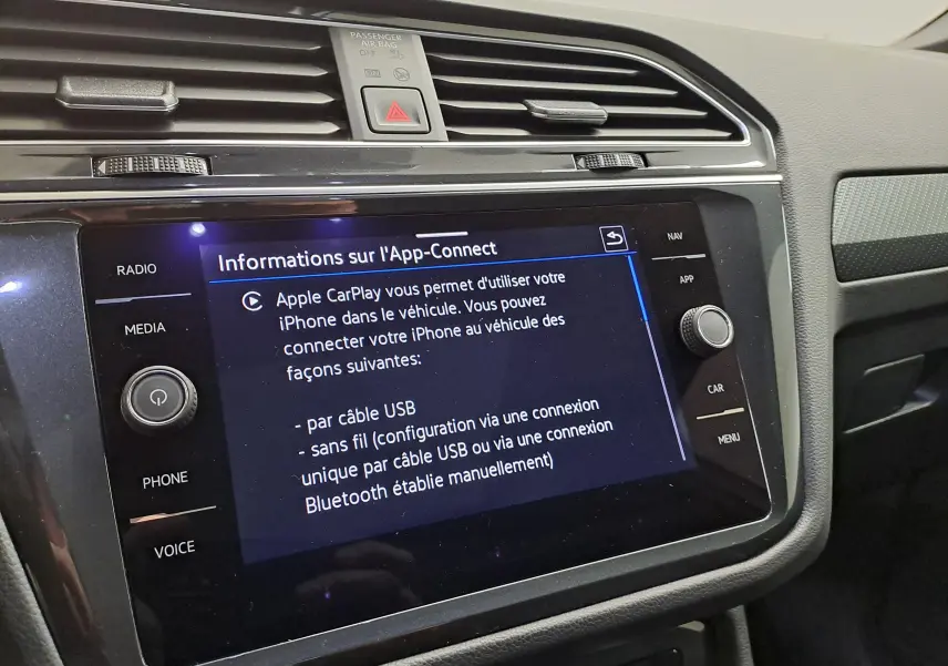 Vue intérieure du tableau de bord du Volkswagen Tiguan 2023, écran tactile affichant les options Apple CarPlay.
