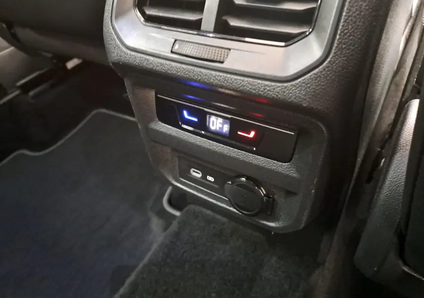 Détail du panneau de contrôle arrière avec réglage des sièges chauffants et prises USB dans un Volkswagen Tiguan blanc nacré.