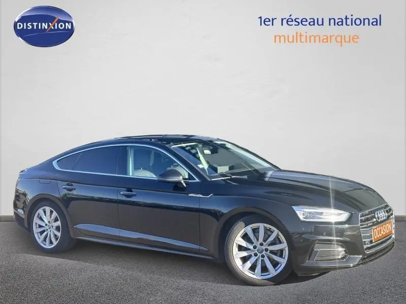 Audi A5 Sportback noire vue de profil côté gauche, avec jantes alu et calandre distinctive à l'avant.
