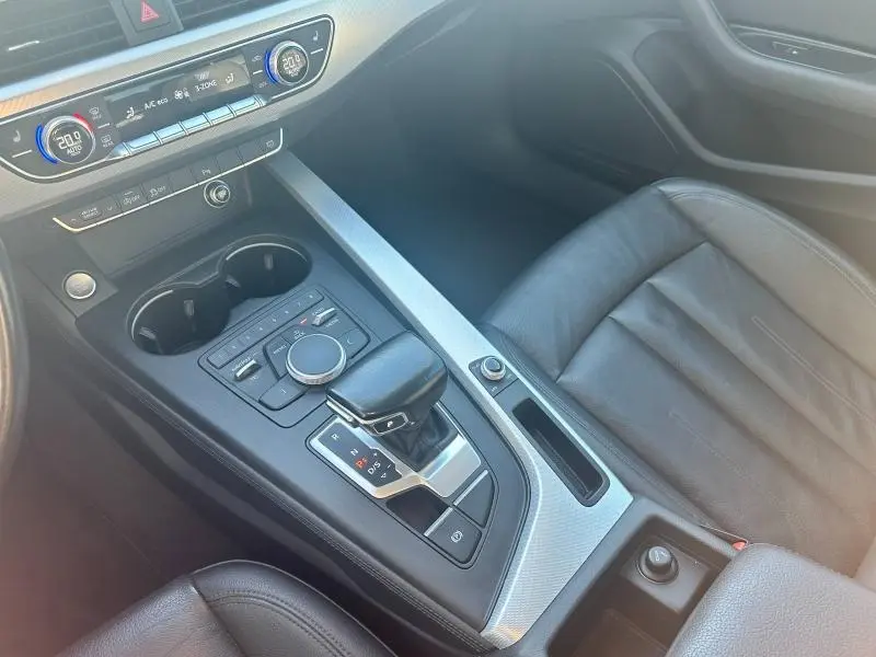 Vue intérieure centrée sur la console centrale et le siège passager en cuir noir de l'Audi A5 Sportback 2018.
