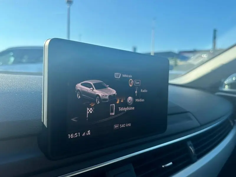 Écran multimédia intérieur affichant un véhicule gris argent et les options son, radio, médias et téléphone.